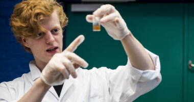 Elev der står med en væske i et reagensglas