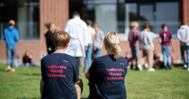 UDFORSKE FORSTÅ FORANDRE står på ryggen af to elevers T-shirts